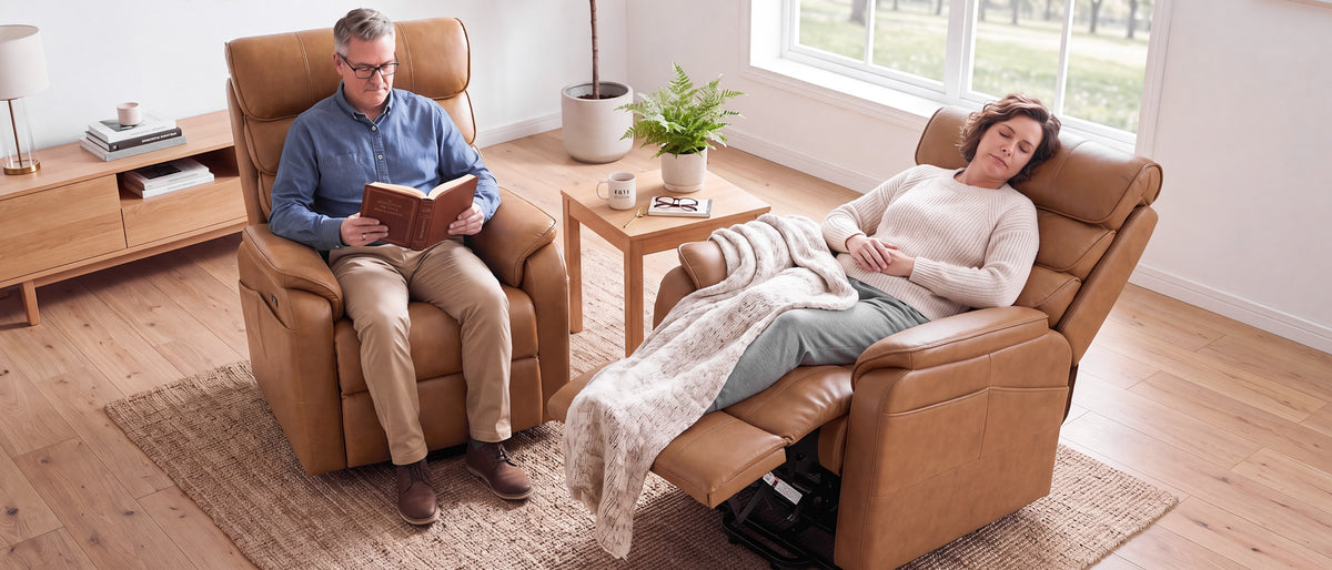 A woman napping under a blanket in a reclined Irene House Pro lift recliner while her husband reads in the matching chair beside her