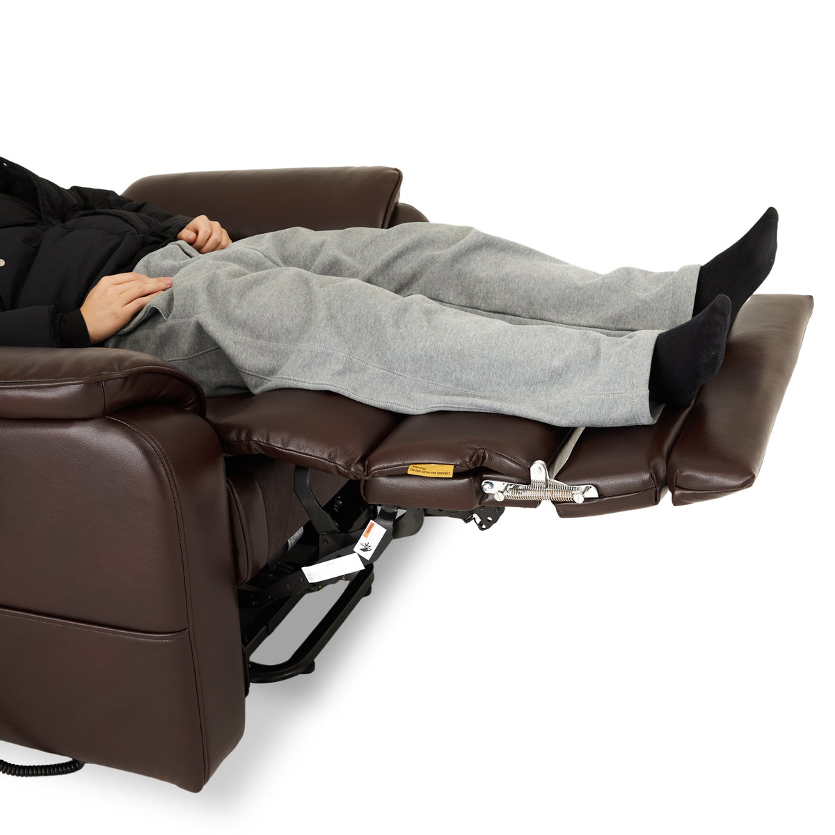 Man lying back under a blanket in the Irene House 9188 EWT500 500 lb lift recliner reclined to 165 degrees, legs fully supported to the heel