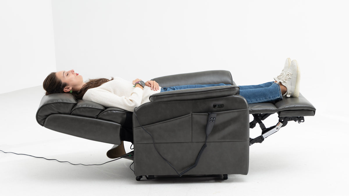 Irene House dark gray power lift recliner in lay-flat position with woman resting, feet elevated